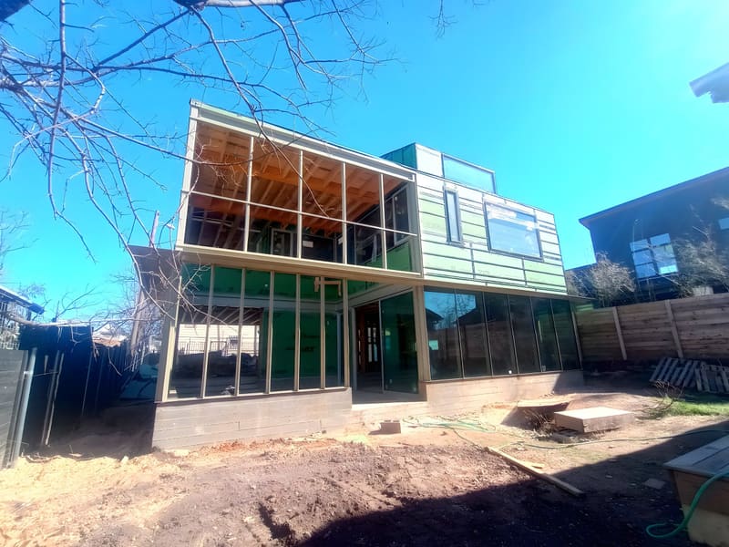 Austin residence under construction — framing and window openings in place, structure legible before it is enclosed