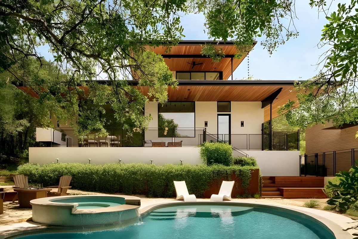 Side by Side — A pool and outdoor living project engineered beneath a cantilevered roof that carries the architecture out over the water.